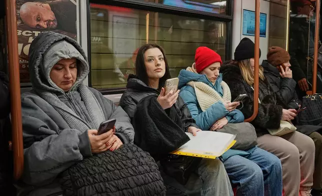 Passengers look at their smartphones while on the subway in Moscow, Wednesday, Feb. 11, 2026. (AP Photo/Alexander Zemlianichenko)