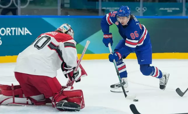 United States' Jack Hughes, right, shoots against Denmark's goalkeeper Mads Sogaard during a preliminary round match of men's ice hockey between United States and Denmark at the 2026 Winter Olympics, in Milan, Italy, Saturday, Feb. 14, 2026. (AP Photo/Petr David Josek)