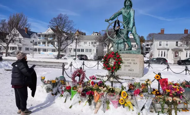 Christine Porper of Gloucester, Mass. pauses at the fisherman's memorial near the homeport of a fishing boat that went missing with seven onboard, Monday, Feb. 2, 2026, in Gloucester, Mass. (AP Photo/Charles Krupa)