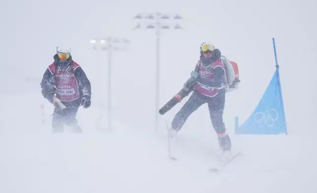 Workers blow snow off the course during the men's ski cross final at the 2026 Winter Olympics, in Livigno, Italy, Saturday, Feb. 21, 2026. (AP Photo/Abbie Parr)