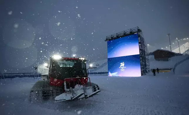 Snowcat driver Oliviero Galli cleans up courses after a weather delay postponed the women's freestyle skiing halfpipe final at the 2026 Winter Olympics, in Livigno, Italy, Saturday, Feb. 21, 2026. (AP Photo/Andy Bao)