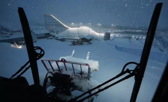 Snowcat driver Oliviero Galli cleans up courses after a weather delay postponed the women's freestyle skiing halfpipe final at the 2026 Winter Olympics, in Livigno, Italy, Saturday, Feb. 21, 2026. (AP Photo/Andy Bao)