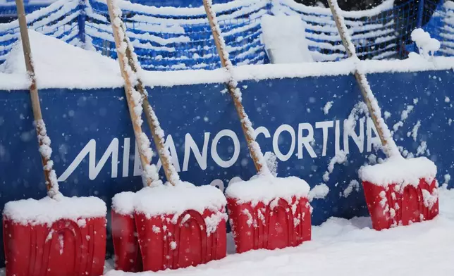 Heavy snow falls on shovels during a weather delay before the women's freestyle skiing halfpipe final at the 2026 Winter Olympics, in Livigno, Italy, Saturday, Feb. 21, 2026. (AP Photo/Lindsey Wasson)