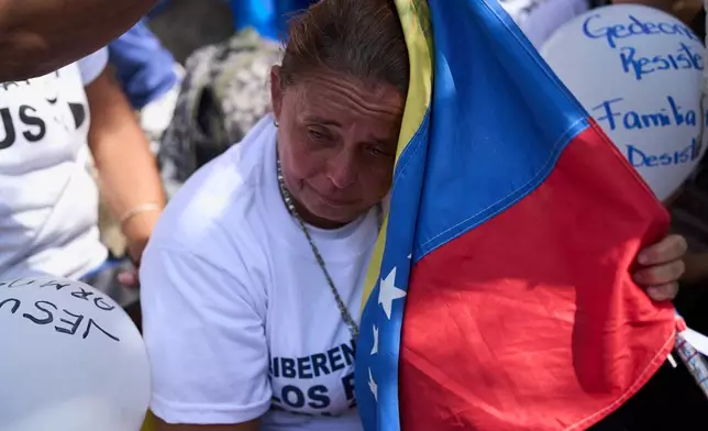 People attend a prayer for freedom of political prisoners, peace and reconciliation, near the Helicoide detention center in Caracas, Venezuela, Saturday, Feb. 7, 2026. (AP Photo/Ariana Cubillos)