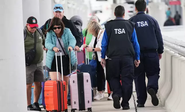 FILE - Travelers walk with their luggage past TSA agents at Fort Lauderdale-Hollywood International Airport, Nov. 13, 2025, in Fort Lauderdale, Fla. (AP Photo/Lynne Sladky, File)