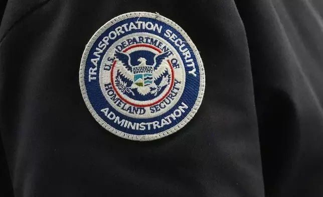 FILE - A TSA agent wears a Transportation Security Administration badge while checking identification at O'Hare International Airport in Chicago,, Nov. 12, 2025. (AP Photo/Nam Y. Huh, File)