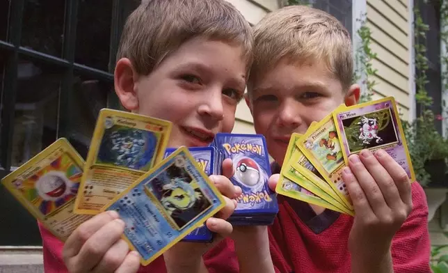 FILE - Tyler, right, and his friend George, hold up their favorite Pokemon trading cards, in Scituate, Mass., Sept. 9, 1999. (AP Photo/Charles Krupa, File)