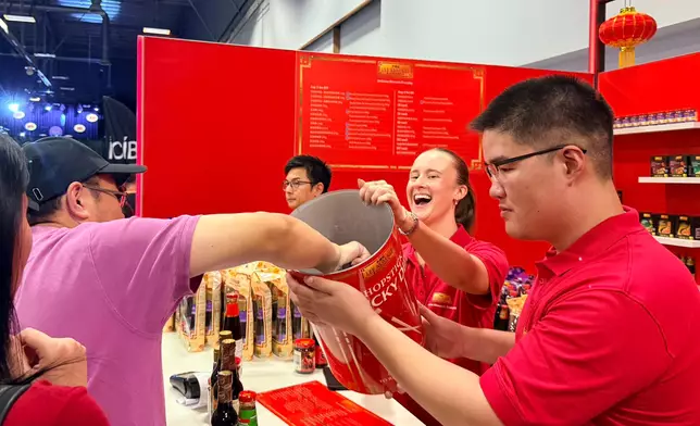 A visitor tries his luck by drawing chopsticks from the luck dip game.