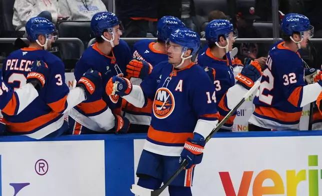 New York Islanders' Bo Horvat (14) celebrates with teammates after scoring a goal during the first period of an NHL hockey game against the Dallas Stars Thursday, March 26, 2026, in Elmont, N.Y. (AP Photo/Frank Franklin II)