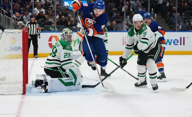 Dallas Stars goaltender Jake Oettinger (29) and Nils Lundkvist (5) protect the net from New York Islanders defenseman Matthew Schaefer (48) during the second period of an NHL hockey game Thursday, March 26, 2026, in Elmont, N.Y. (AP Photo/Frank Franklin II)