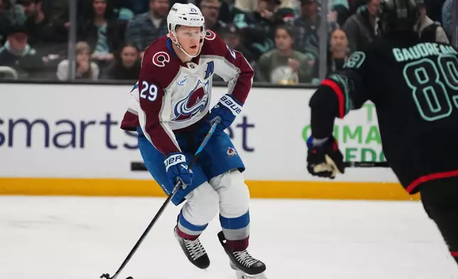 Colorado Avalanche center Nathan MacKinnon (29) moves the puck against Seattle Kraken center Frederick Gaudreau (89) during the first period of an NHL hockey game Thursday, March 12, 2026, in Seattle. (AP Photo/Lindsey Wasson)