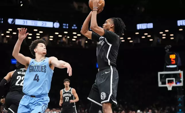 Brooklyn Nets' Ziaire Williams (1) shoots over Memphis Grizzlies' Walter Clayton Jr. (4) during the first half of an NBA basketball game Monday, March 9, 2026, in New York. (AP Photo/Frank Franklin II)