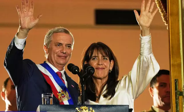 Chile's President Jose Antonio Kast and his wife Maria Pia Adriasola wave to supporters from the balcony of La Moneda presidential palace after his inauguration in Santiago, Chile, Wednesday, March 11, 2026. (AP Photo/Esteban Felix)