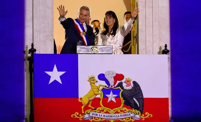 Chile's President Jose Antonio Kast and his wife Maria Pia Adriasola wave to supporters from the balcony of la Moneda presidential palace after his inauguration in Santiago, Chile, Wednesday, March 11, 2026. (AP Photo/Cristobal Basaure)