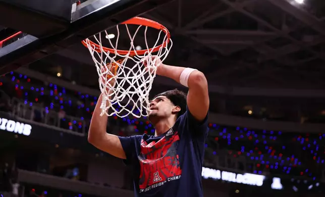 Arizona forward Koa Peat cuts down the net after a win over Purdue in the Elite Eight of the NCAA college basketball tournament, Saturday, March 28, 2026, in San Jose, Calif. (AP Photo/Kelley L Cox)