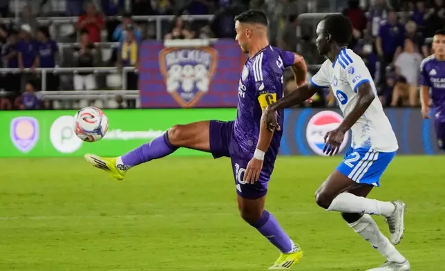 Orlando City midfielder Martin Ojeda, left, moves the ball past CF Montreal midfielder Victor Loturi during the second half of an MLS soccer match, Saturday, March 14, 2026, in Orlando, Fla. (AP Photo/John Raoux)