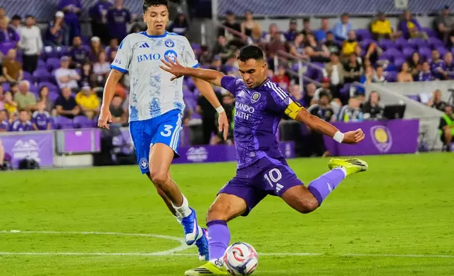Orlando City midfielder Martin Ojeda (10) takes a shot on goal ahead of CF Montreal defender Tomas Aviles (3) during the second half of an MLS soccer match, Saturday, March 14, 2026, in Orlando, Fla. (AP Photo/John Raoux)