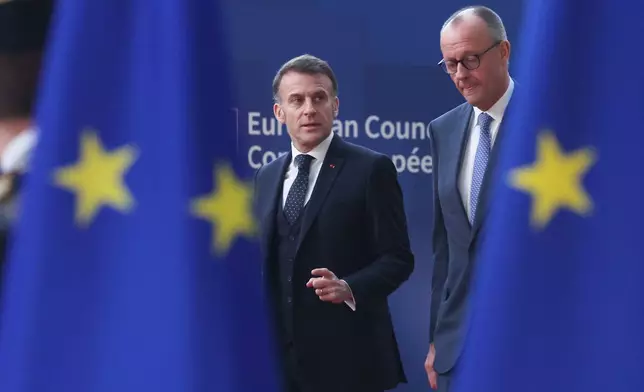 Germany's Chancellor Friedrich Merz, right, and French President Emmanuel Macron walk together as they arrive for the EU summit at the European Council building in Brussels, Thursday, March 19, 2026. (AP Photo/Omar Havana)