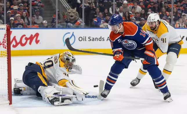 Nashville Predators goalie Justus Annunen, left, makes a save on Edmonton Oilers' Zach Hyman (18) during the second period of an NHL hockey game in Edmonton, Alberta, Sunday, March 15, 2026. (Jason Franson/The Canadian Press via AP)