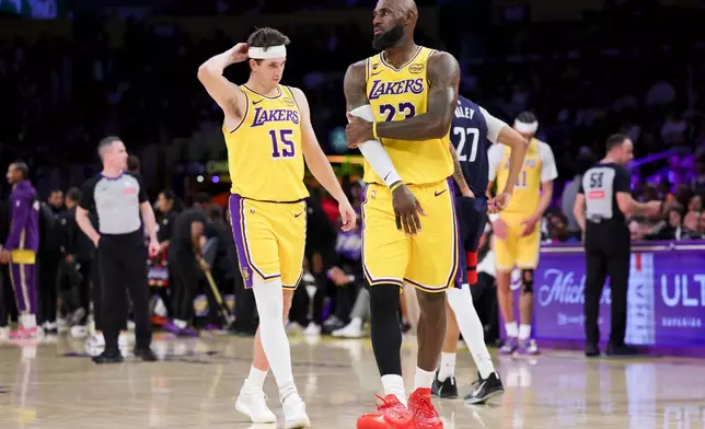 Los Angeles Lakers forward LeBron James, right, and guard Austin Reaves stand during a timeout during the first half of an NBA basketball game against the Washington Wizards Monday, March 30, 2026, in Los Angeles. (AP Photo/Ryan Sun)