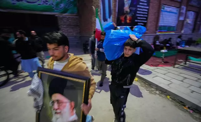 A boy carries a plastic bag of donated items collected during a relief drive for Iran in Budgam, Indian-controlled Kashmir, Monday, March 23, 2026. (AP Photo/Mukhtar Khan)