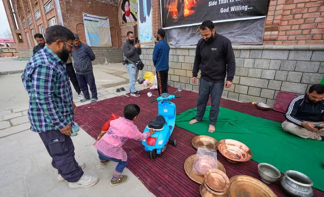 A boy donates his toy scooter during a relief drive for Iran in Budgam, Indian-controlled Kashmir, Monday, March 23, 2026. (AP Photo/Mukhtar Khan)