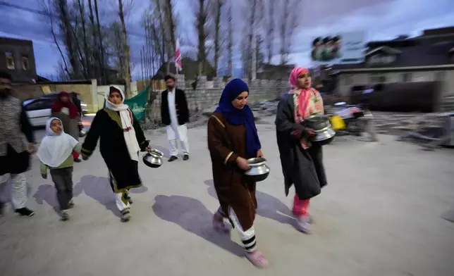 Shiite Muslim women arrive carrying kitchenware to donate at a relief drive for Iran in Budgam, Indian-controlled Kashmir, Monday, March 23, 2026. (AP Photo/Mukhtar Khan)