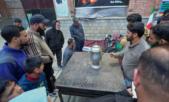 A volunteer auctions a donated copper vessel to raise cash for a relief drive for Iran in Budgam, Indian-controlled Kashmir, Monday, March 23, 2026. (AP Photo/Mukhtar Khan)