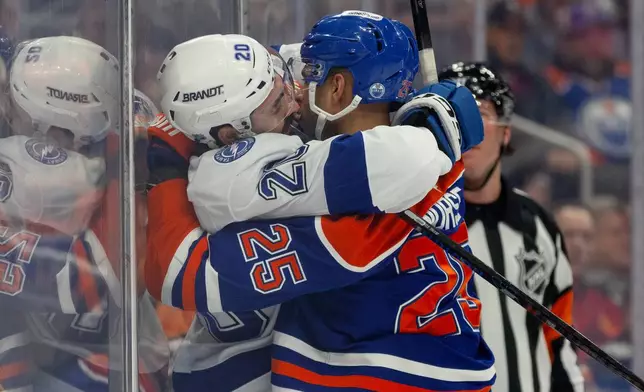 Tampa Bay Lightning's Nick Paul (20) and Edmonton Oilers' Darnell Nurse (25) rough it up during first-period NHL hockey game action in Edmonton, Alberta, Saturday March 21, 2026. (Jason Franson/The Canadian Press via AP)
