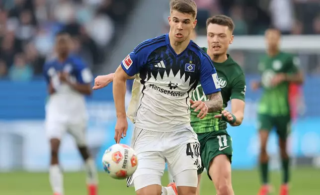 Wolfsburg's Dzenan Pejcinovic, right, and Hamburger's Luka Vuskovic battle for the ball during their German Bundesliga soccer match in Wolfsburg, Germany, Saturday, March 7, 2026. (Andreas Gora/dpa via AP)