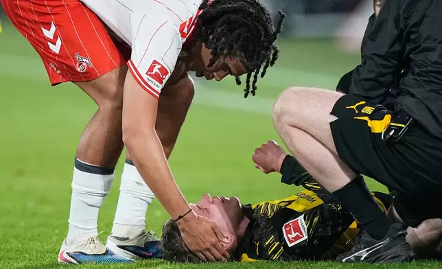 Cologne's Jahmai Simpson-Pusey, left, comforts fouled Dortmund's Maximilian Beier, before he gets the red card during a German Bundesliga soccer match between 1.FC Koeln and Borussia Dortmund in Cologne, Germany, Saturday, March 7, 2026. (AP Photo/Martin Meissner)