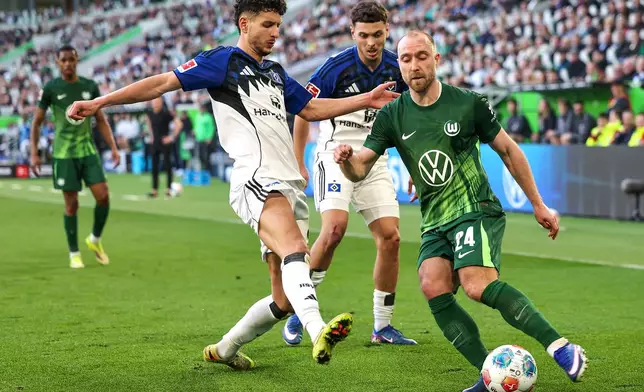 Wolfsburg's Christian Eriksen, right, and Hamburger's Daniel Elfadli battle for the ball during their German Bundesliga soccer match in Wolfsburg, Germany, Saturday, March 7, 2026. (Andreas Gora/dpa via AP)