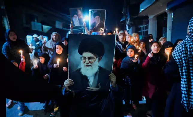 Shiite Muslims shout slogans during a candlelit protest against the killing of Iran's Supreme Leader Ayatollah Ali Khamenei, in Srinagar, Indian controlled Kashmir, Wednesday, March 4, 2026. (AP Photo/Mukhtar Khan)