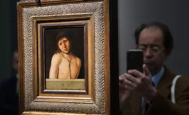 Journalists look at Antonello da Messina's Ecce Homo, a tempera-on-panel painting dating from around 1470 and measuring 20.3 by 14.9 centimeters, recently acquired by the Italian General Directorate of Museums for $14.9 million, or about 12.6 million euros in Rome, Thursday, March 26, 2026 . (AP Photo/Domenico Stinellis)