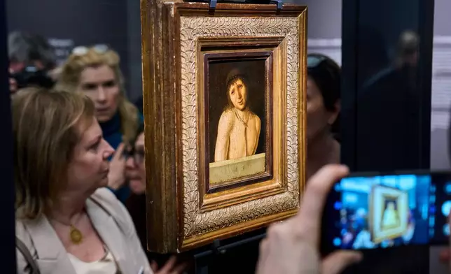 Journalists look at Antonello da Messina's Ecce Homo, a tempera-on-panel painting dating from around 1470 and measuring 20.3 by 14.9 centimeters, recently acquired by the Italian General Directorate of Museums for $14.9 million, or about 12.6 million euros in Rome, Thursday, March 26, 2026 . (AP Photo/Domenico Stinellis)