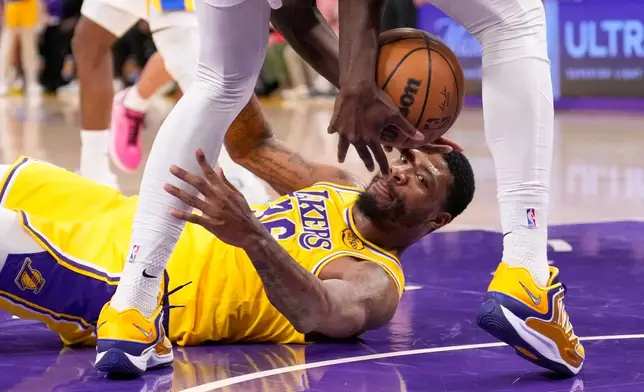 Los Angeles Lakers guard Marcus Smart, below, grapples for a loose ball with Indiana Pacers forward Pascal Siakam during the third period of an NHL hockey game Friday, March 6, 2026, in Los Angeles. (AP Photo/Mark J. Terrill)