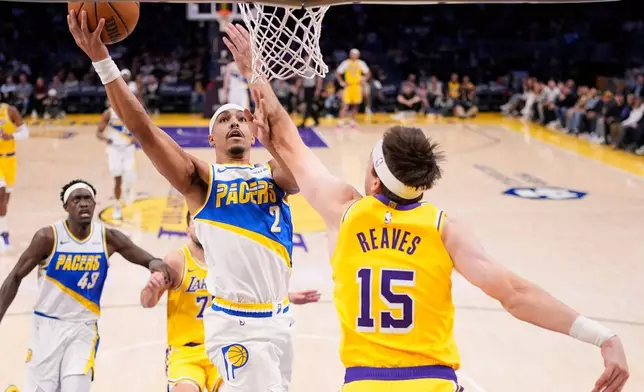 Indiana Pacers guard Andrew Nembhard (2) shoots as Los Angeles Lakers guard Austin Reaves (15) defends during the third period of an NHL hockey game Friday, March 6, 2026, in Los Angeles. (AP Photo/Mark J. Terrill)
