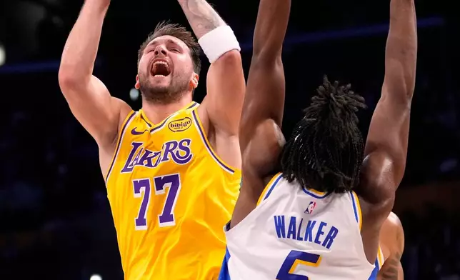 Los Angeles Lakers guard Luka Doncic, left, shoots as Indiana Pacers forward Jarace Walker defends during the first half of an NBA basketball game Friday, March 6, 2026, in Los Angeles. (AP Photo/Mark J. Terrill)