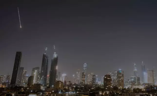 Missiles launched from Iran are seen in the sky over central Israel, Thursday, March 12, 2026. (AP Photo/Ohad Zwigenberg)
