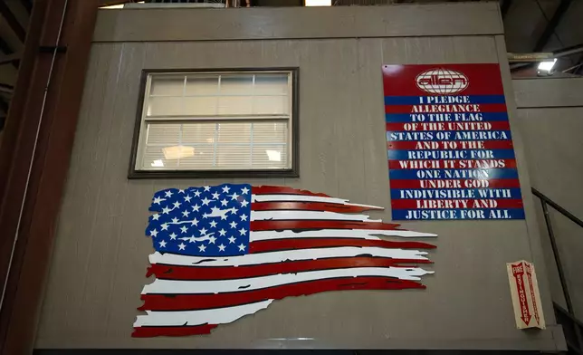 An American flag and the Pledge of Allegiance is seen inside the Allen Engineering Corporation plant Monday, March 16, 2026, in Paragould, Ark. (AP Photo/Kevin Wurm)