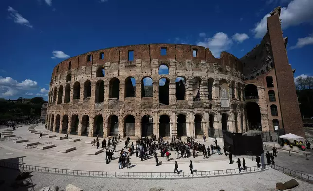 People walk in the new outdoor space created with travertine marble around the Colosseum during it's inauguration in Rome, Tuesday, March 17, 2026. (AP Photo/Andrew Medichini)
