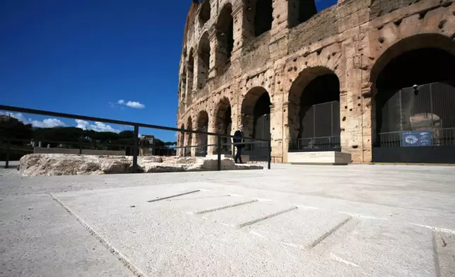 People walk in the new outdoor space created with travertine marble around the Colosseum during it's inauguration in Rome, Tuesday, March 17, 2026. (AP Photo/Andrew Medichini)