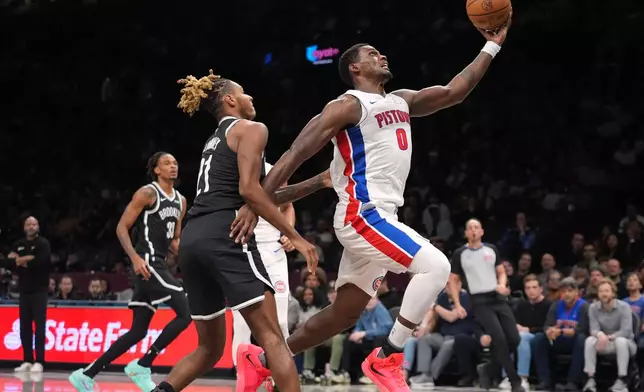 Detroit Pistons' Jalen Duren (0) drives past Brooklyn Nets' Noah Clowney (21) during the first half of an NBA basketball game Tuesday, March 10, 2026, in New York. (AP Photo/Frank Franklin II)