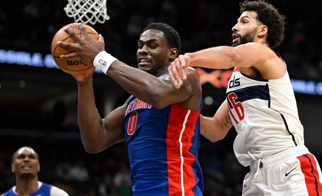 Detroit Pistons center Jalen Duren (0) grabs a rebound against Washington Wizards forward Anthony Gill during the first half of an NBA basketball game, Tuesday, March 17, 2026, in Washington. (AP Photo/John McDonnell)