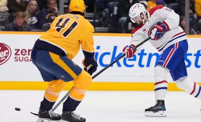 Montreal Canadiens defenseman Noah Dobson (53) shoots the puck past Nashville Predators defenseman Nicolas Hague (41) during the first period of an NHL hockey game Saturday, March 28, 2026, in Nashville, Tenn. (AP Photo/George Walker IV)
