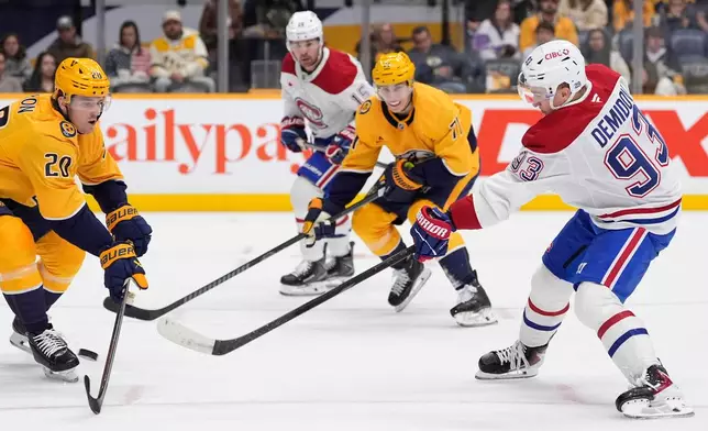 Montreal Canadiens right wing Ivan Demidov (93) shoots the puck past Nashville Predators defenseman Justin Barron (20) during the first period of an NHL hockey game Saturday, March 28, 2026, in Nashville, Tenn. (AP Photo/George Walker IV)