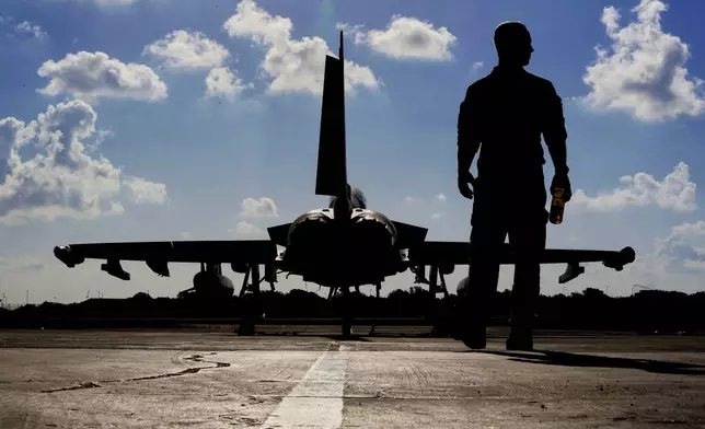FILE - A British soldier walks by a Typhoon aircraft before take off for a mission in Iraq, at RAF Akrotiri, near the southern coastal city of Limassol, Cyprus, Sept. 22, 2016. (AP Photo/Petros Karadjias, File)