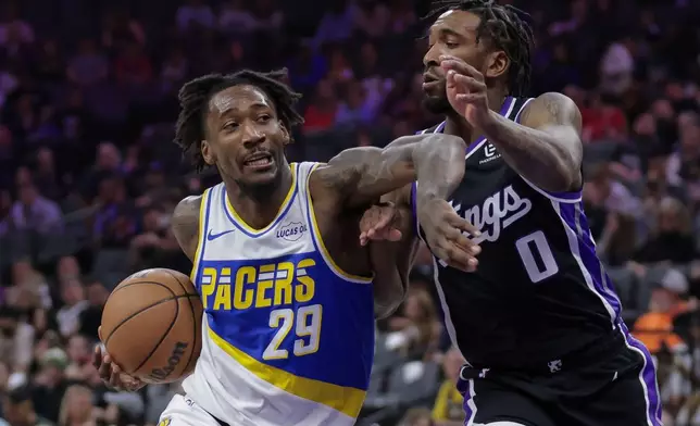 Indiana Pacers guard Quenton Jackson (29) drives towards the basket while being guarded by Sacramento Kings guard Malik Monk (0) during the first half of an NBA basketball game Tuesday, March 10, 2026, in Sacramento, Calif. (AP Photo/Scott Marshall)