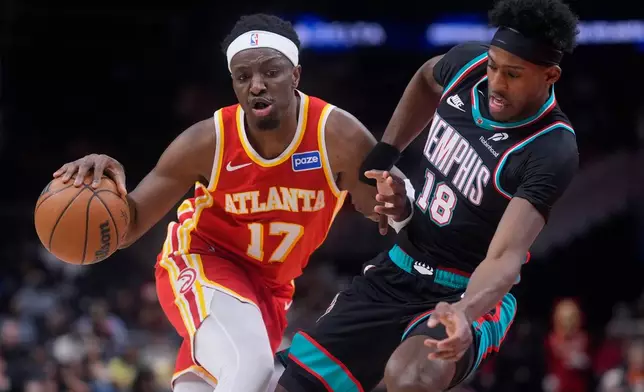 Atlanta Hawks forward Onyeka Okongwu (17) drives against Memphis Grizzlies forward Olivier-Maxence Prosper (18) during the first half of an NBA basketball game, Monday, March 23, 2026, in Atlanta. (AP Photo/Mike Stewart)