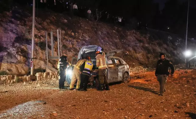 Israeli security forces inspect the scene of a direct hit on a road following an Iranian missile strike in Jerusalem, Sunday, March 1, 2026.(AP Photo/Mahmoud Illean)